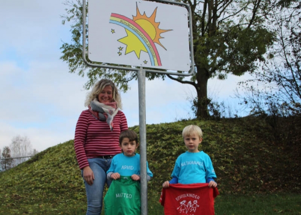 Gut zu finden: Kita-Leiterin Nicole Nolte und zwei der Vorschulkinder am neuen Wegweiser.